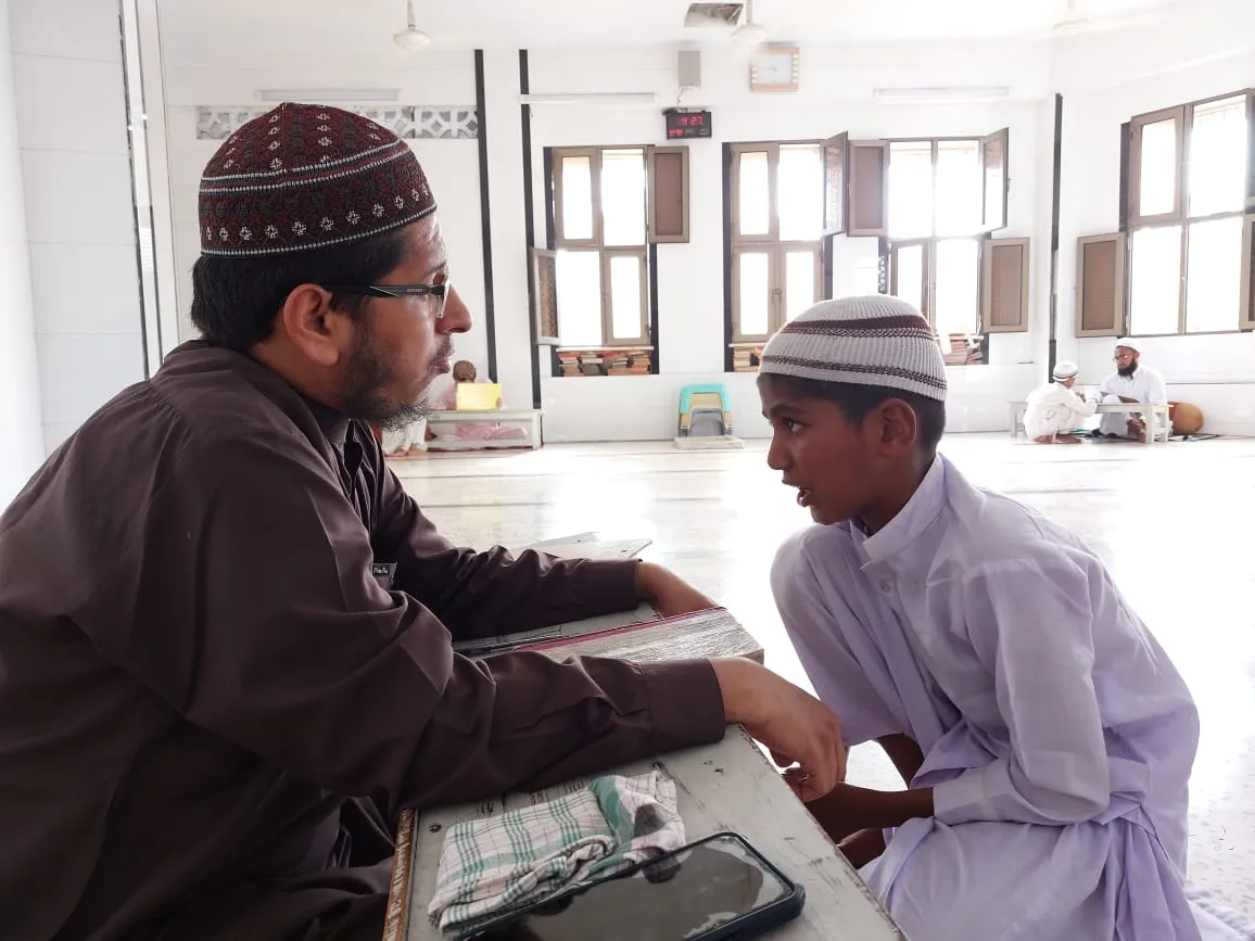 A teacher listening to a student's Qur'an lesson