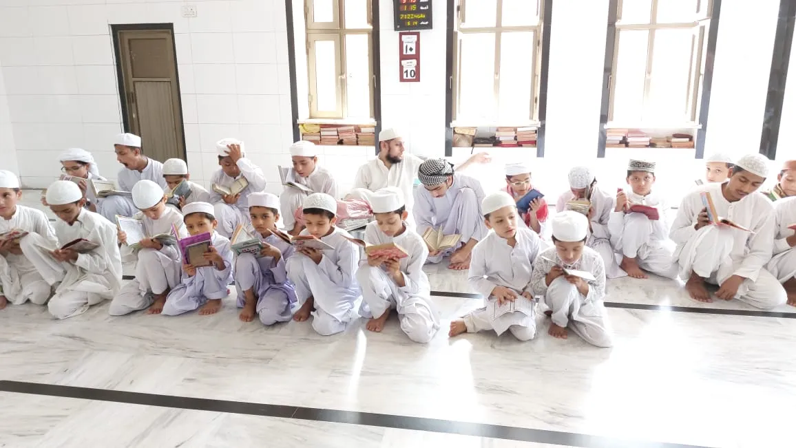 Students seated in rows reciting the Qur'an